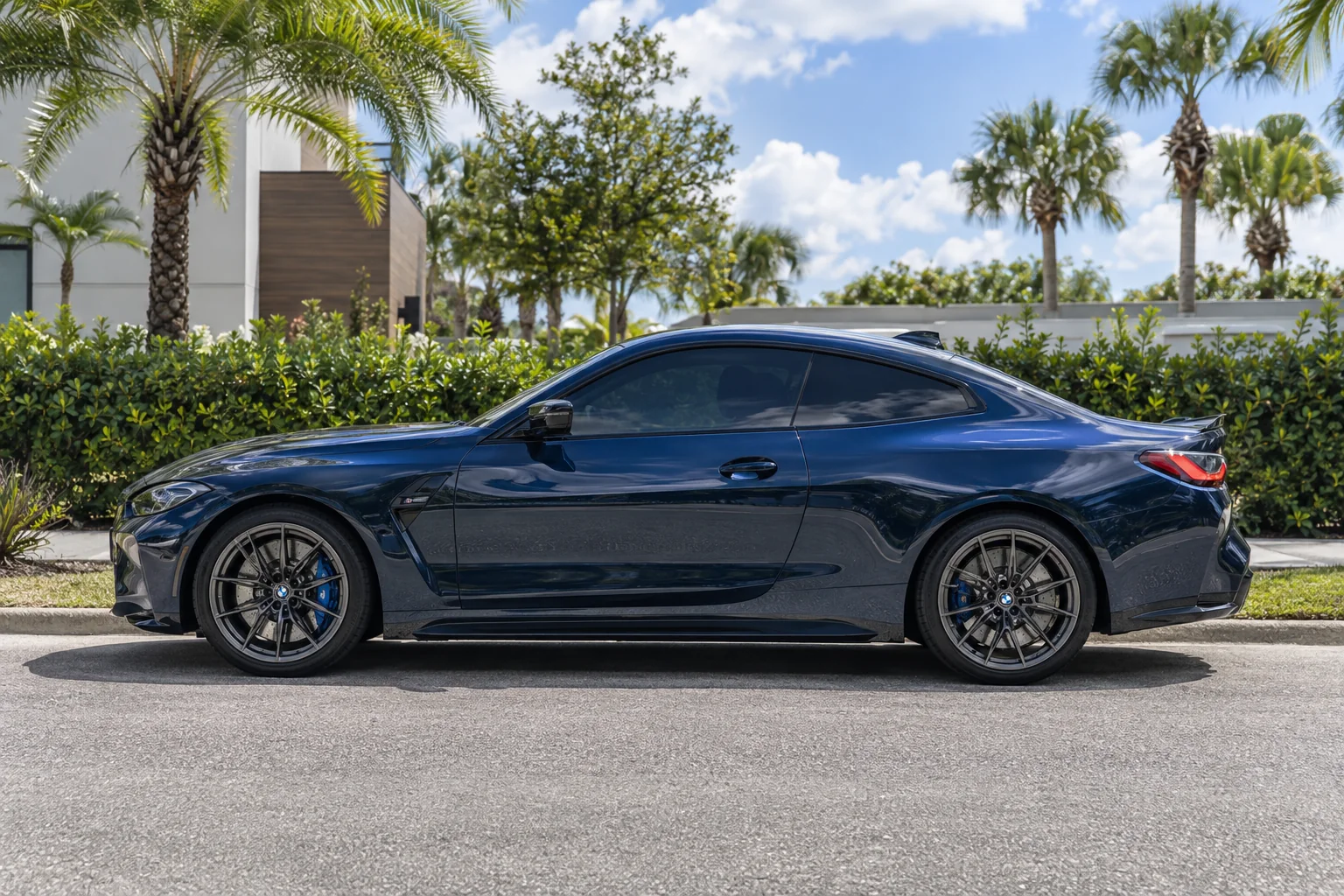 Deep navy blue metallic BMW M4 coupe with tinted windows at Dynamic Tinting Solution