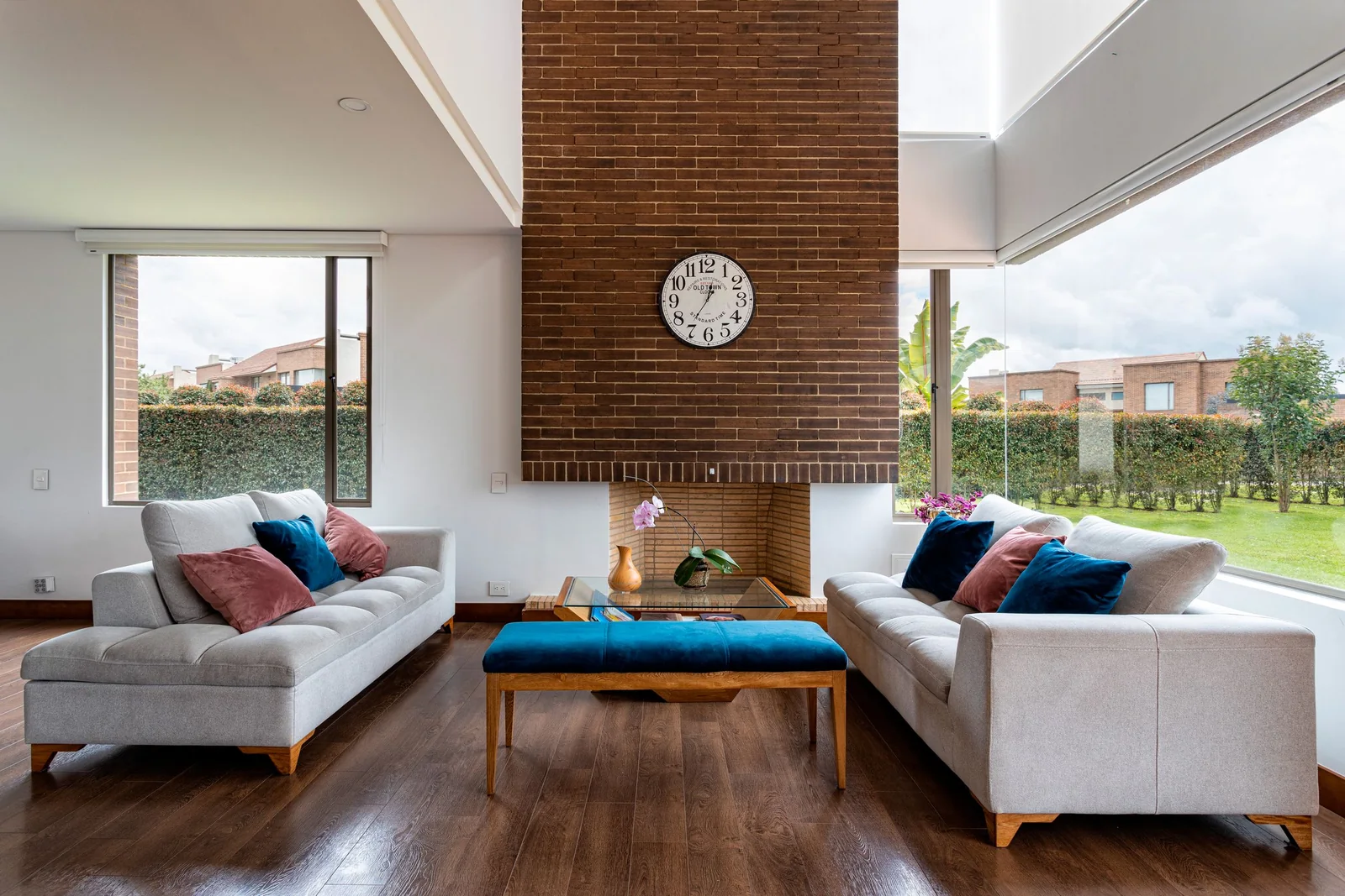 Bright and comfortable contemporary living room with brick fireplace and large windows.