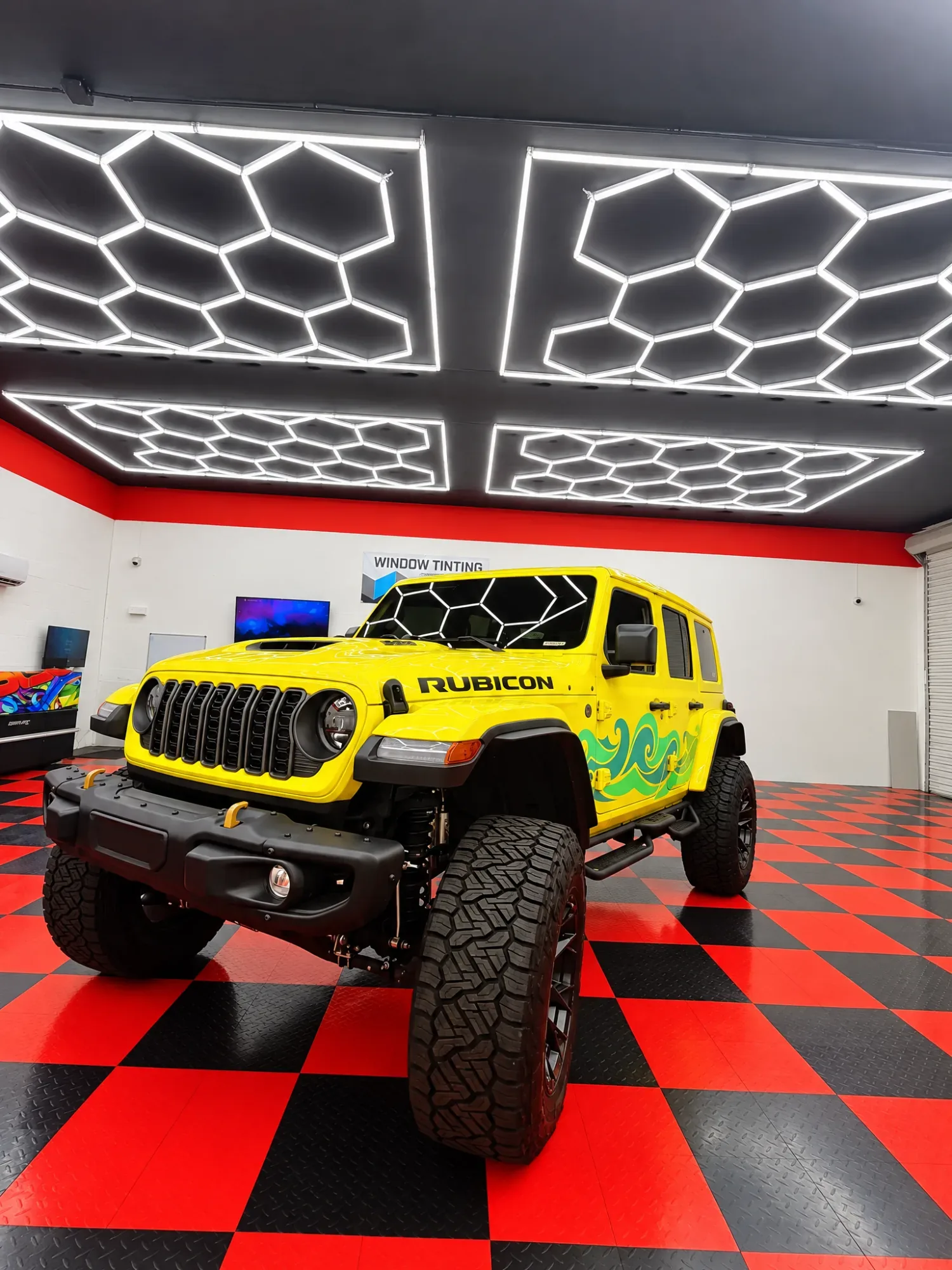 Yellow Jeep Wrangler Rubicon with tinted windows in the Dynamic Tinting Solution shop in Largo, FL